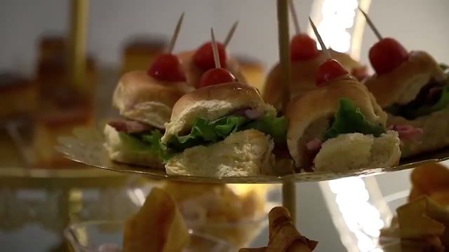 Mini sándwiches con tomate cherry servidos en niveles de cristal